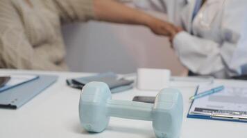 A doctor is holding a dumbbell in front of a desk video