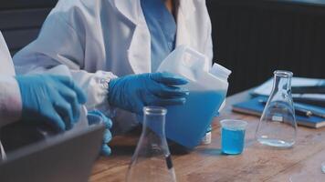 Two people in lab coats are working on a project video