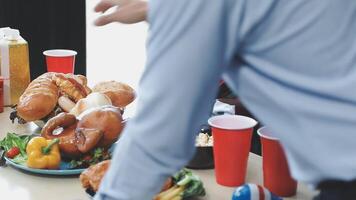 A man is standing over a table with food video