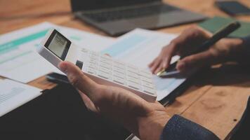 Businessman using calculator to calculate the cost of a project video
