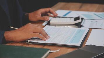 Businessman's hands on paper and calculator video