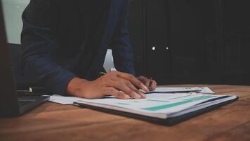 A person is writing on a piece of paper while sitting at a desk video
