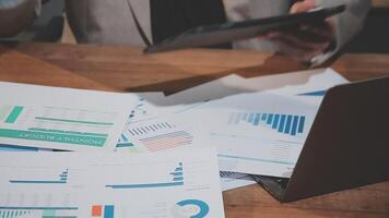 Businessman using laptop and papers with graphs video