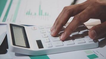 A person's hand is on a calculator and a piece of paper video