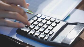 A person is using a calculator to calculate the amount of money video