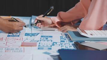 Two people working on a project with papers and pens video