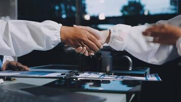 Two people shaking hands over a desk video