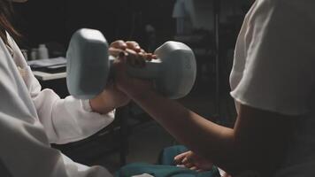A woman is lifting a dumbbell with another woman video