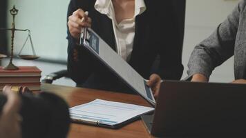 A woman in a business suit is holding a clipboard while another woman is taking notes video