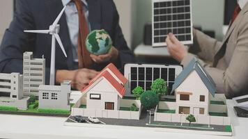 Two men are looking at a model of a house with solar panels video