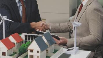 Two men shaking hands over a model of a house video