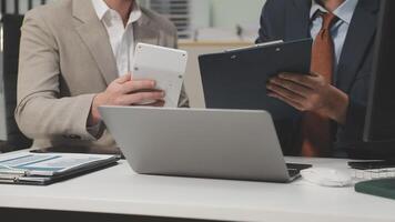 Two business people are looking at a tablet computer video