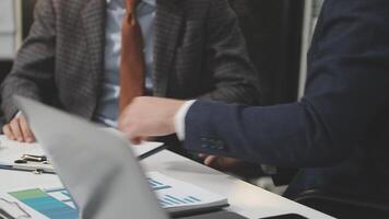Two business people sitting at a table with laptops video