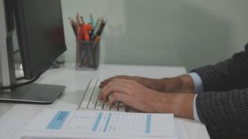 A person typing on a keyboard and looking at a computer screen video