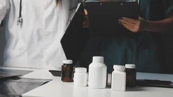 Two doctors are standing near a table with bottles and pills video