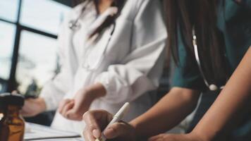 Two women in scrubs writing on a piece of paper video
