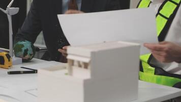 Two people working on a model of a building video