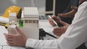Two people are working on a model of a house video