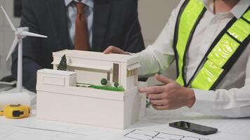 Two men are working on a model of a house video