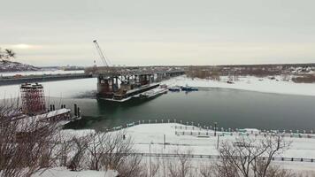 A view of a bridge over a river in the winter video