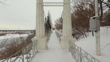 A bridge over a snowy river with a snow covered path video