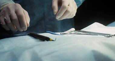 Close-up of a surgeon's hands in disposable gloves choosing an instrument for work and starting an operation. No face. 4k, red komodo video