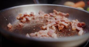Pasta is added to bacon and fried together in a frying pan, close-up, no people video