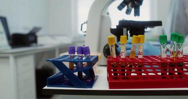 Flasks with blood stratified after centrifuge are on table of laboratory assistant who checks the analyzes, looking through a microscope. Close-up, no face, unrecognizable person. 4k, red komodo video