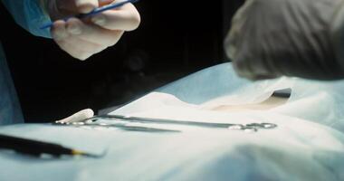 The surgeon's hands cutting patient's abdomen with a scalpel at beginning of operation. The assistant assists surgeon by dipping the blood. Teamwork of doctors in the operating room. 4k, red komodo video