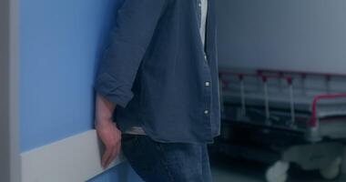 The man is nervous standing in the hospital corridor and waiting for the result of the operation video