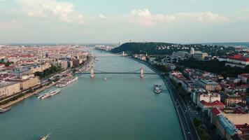 Aerial view of Budapest featuring Chain Bridge spanning Danube River with cityscape in background. Architecture and famous landmark of Budapest, Hungary video