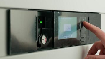 Close-up of person adjusting temperature on heat pump control panel with digital screen. Concept of home heating and energy efficiency in modern systems video