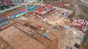 Aerial view of construction site with cranes, foundations and building materials. Residential building under construction. Progress of new development in small town video