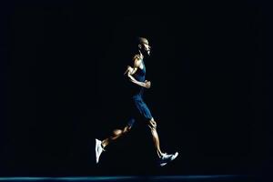 A dynamic full-length portrait of a man running, captured in motion against a solid black background. The image embodies energy, determination, and the power of sport and athleticism photo