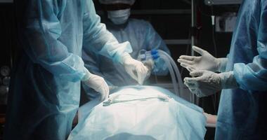 The surgeon makes an incision with a scalpel in a disposable sheet covering the patient. The medical team in the operating room is preparing for the operation. in 4k, red komodo video