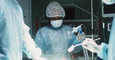 A team of surgeons perform an operation in a bright operating room. in 4k, red komodo video