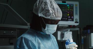 An African-American anesthesiologist puts a mask that ensures the flow of anesthesia on a patient. Preparing for a surgical operation. in 4k, red komodo video