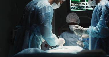 A multinational team of surgeons perform laparoscopic surgery in a modern, well-equipped operating room. in 4k, red komodo video
