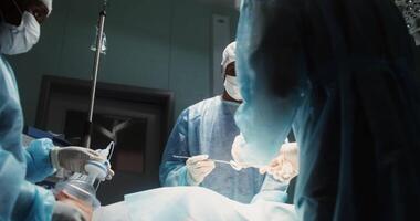 Performing a surgical operation in a modern operating room. There is no patient's blood on the . Clean bright operating room during the operation. Team of surgeons. in 4k, red komodo video