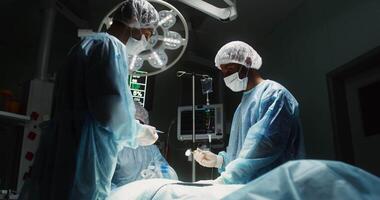 Surgical operation in a modern, well-equipped operating room. The surgeon, his assistant and the anesthetist work as a team. in 4k, red komodo video