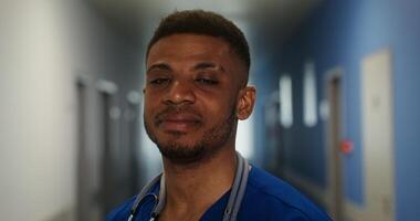 Close-up of a smiling face of an African American doctor with a phonendoscope around his neck smiling and looking directly at the camera. in 4k, red komodo video