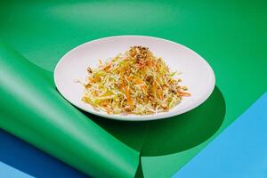 Fresh vegetable salad with colorful ingredients presented on a vibrant green and blue background photo