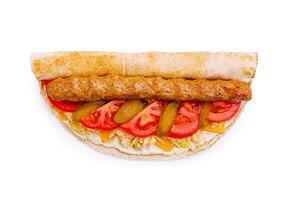 Savory wrap filled with grilled meat, fresh vegetables, and cheese served on a flatbread photo