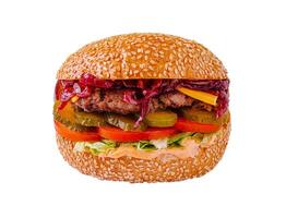 Juicy grilled burger loaded with fresh vegetables and flavorful sauces in a sesame seed bun photo