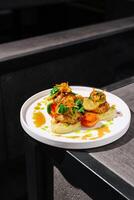 Deliciously plated dish featuring sauteed vegetables and protein in a modern dining setting with minimalistic design photo