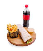 Enjoying a delicious wrap with fries and a beverage on a wooden platter for a satisfying meal photo