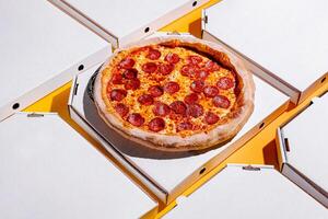 Delicious pepperoni pizza served in delivery boxes on a colorful background during the day photo