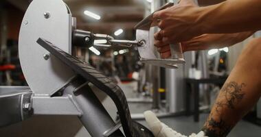 Close-up of a young man's hand pulling on the handrail of an exercise machine, lifting weights. Strength training in a modern gym video