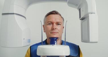 Panoramic x-ray of the patient's jaw, front view, portrait videography, close-up. Diagnostic equipment orthopantomographic device for teeth, MRI. in 4k, red komodo video