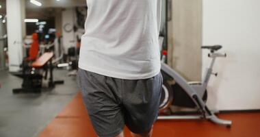 Front view, close-up of male hands pushing down the levers of the exercise machine lifting weights, the man's face is not visible, unidentified identity video